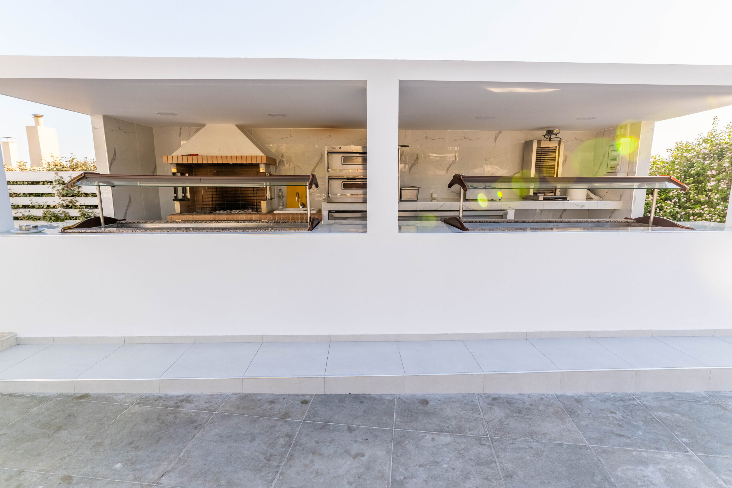 BBQ show cooking at Pefkos Breeze hotel, with a chef grilling meat in an open-air setting.
