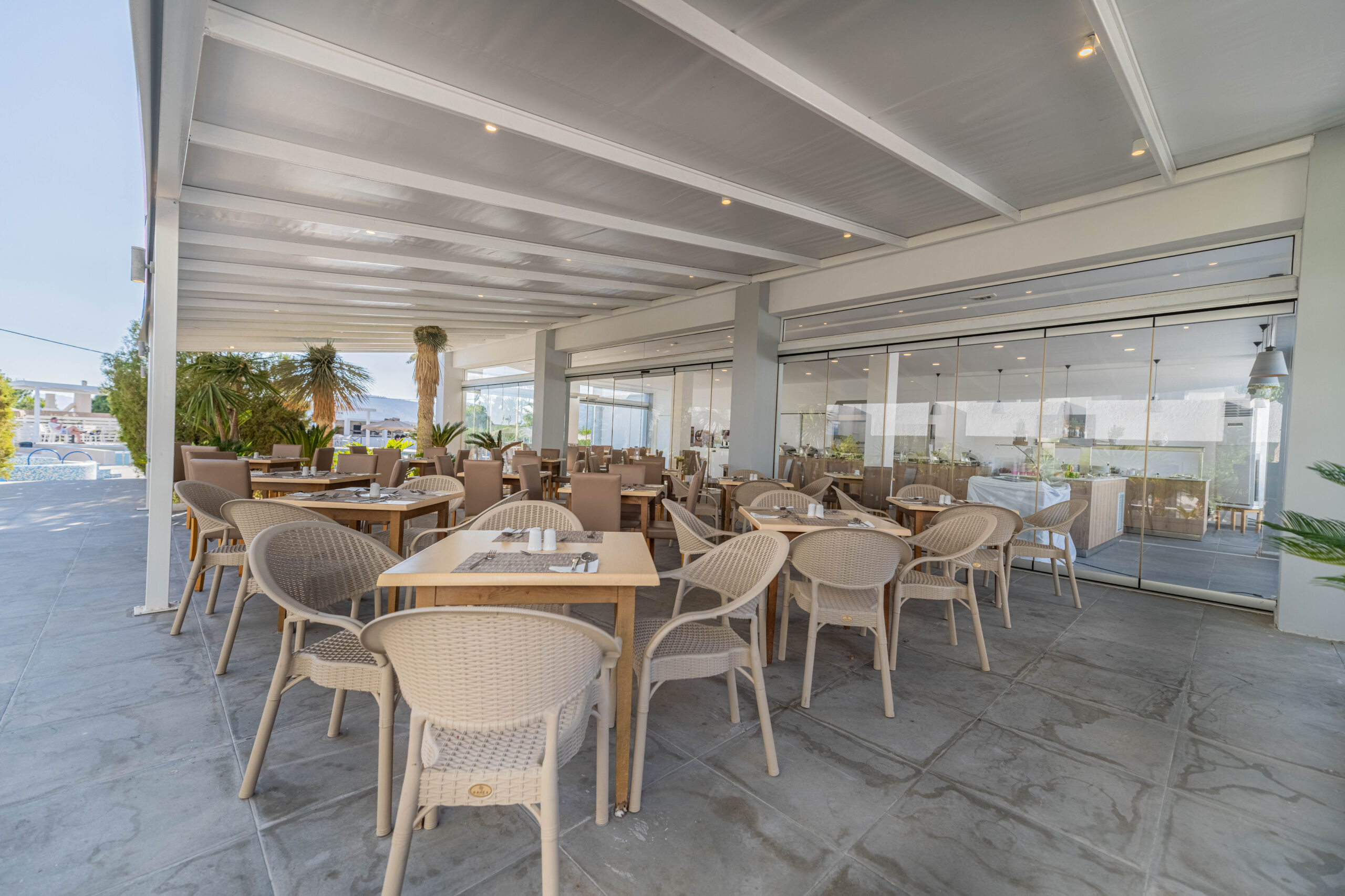 Exterior view of the main restaurant at Pefkos Breeze hotel, featuring a stylish façade and inviting outdoor seating.